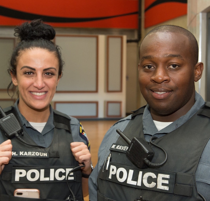 UPD officers Hadeel Karzoun and Maxwell Ravenell III facing the camera and smiling