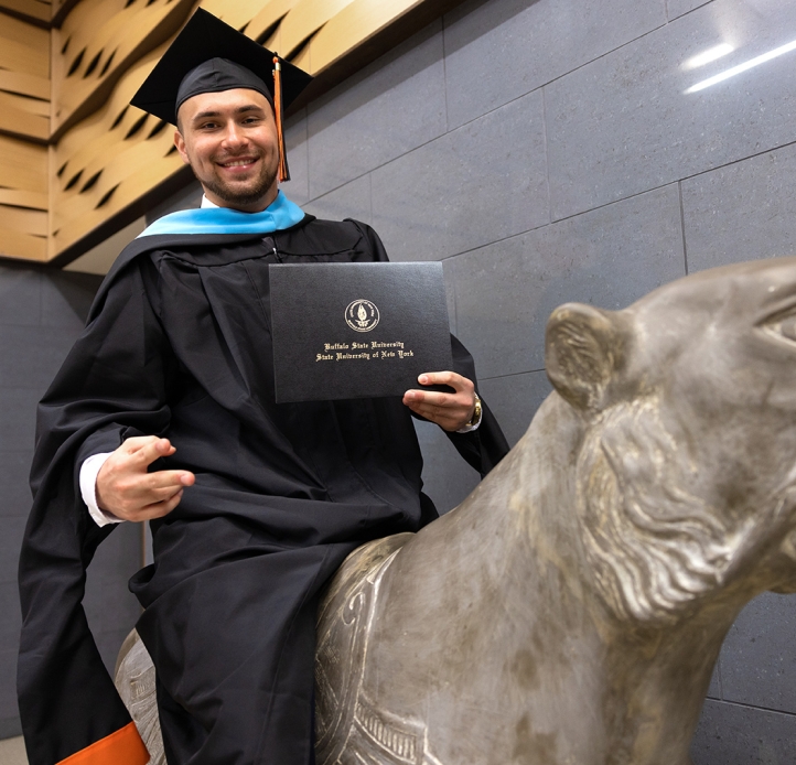 Commencement student sitting on the bengal