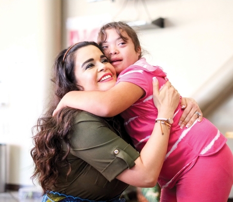 Student with down's syndrome hugs special education teacher