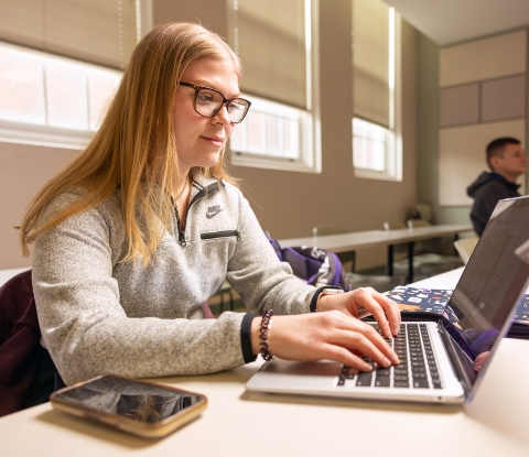 HEA student in class with a laptop