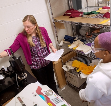 Professor showing student how to use equipment in studio 