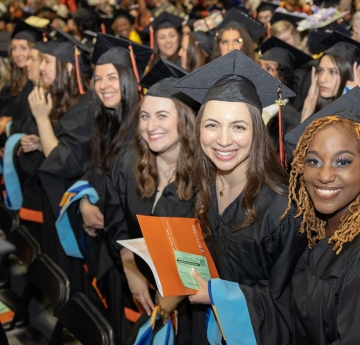 Smiling graduates in the crowd