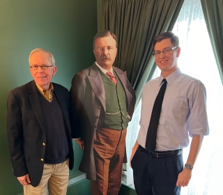 Elderly man and male student with a cutout of Theodore Roosevelt