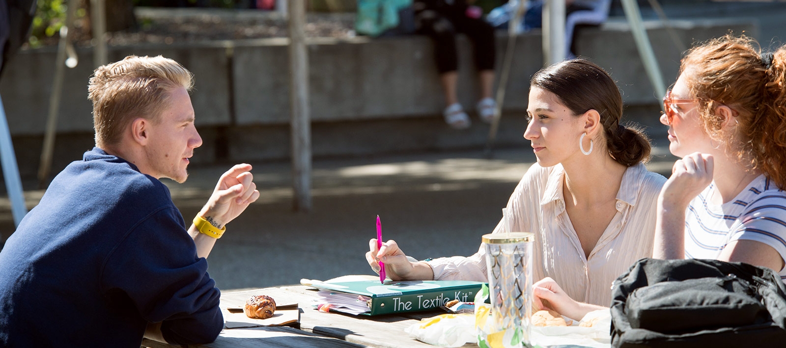 Students talking at a picnic table in the quad